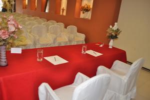 a table with white chairs and a red table cloth at Hotel "VIRGEN DEL SOCAVON" in Oruro