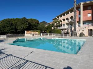 a swimming pool in front of a building at Studio Bohème à St Florent Grande terrasse in Saint-Florent