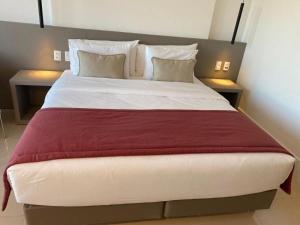 a large bed in a hotel room with two tables at Flat Particular no Hotel Ramada Alvorada Brasília in Brasilia +17 photos