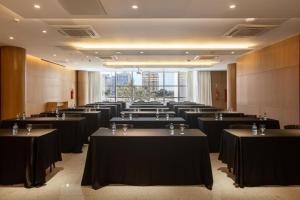 a row of tables in a large room with tables sidx sidx at Flat Particular no Hotel Ramada Alvorada Brasília in Brasilia