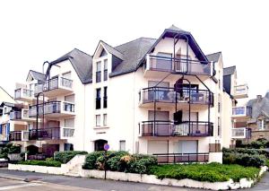 Un gran edificio blanco con balcones en una calle. en Le Belvédère de Port-Lin - Les Gîtes de la Côte d'Amour, en Le Croisic