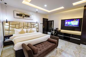 哈科特港Roston Hotels的一间配有一张大床和一台平板电视的卧室