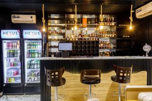 哈科特港Roston Hotels的酒吧设有两把椅子和一个带饮料的吧台