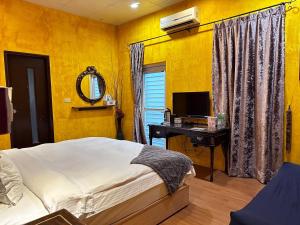 una camera con letto e scrivania con TV di 彤林溫泉民宿 a Jiaoxi