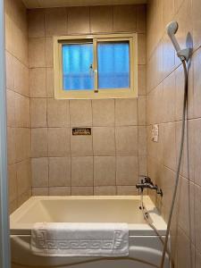 bagno con vasca e finestra di 彤林溫泉民宿 a Jiaoxi Altre 23 foto