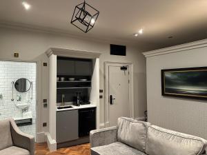 a living room with a couch and a kitchen at King Street Aparthotel in Stirling