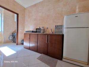 a kitchen with a white refrigerator and wooden cabinets at Spartel House 05 in Tangier