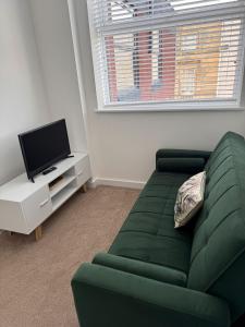 ハルにあるCosy Executive City Apartment 3の緑のソファとテレビのあるリビングルーム