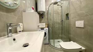 une salle de bain avec douche, lavabo et toilettes dans l'établissement Little Plaza Duplex, à Ljubljana 15 autres photos