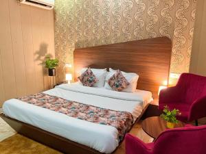 una camera da letto con un letto e una sedia rossa di Hotel Starlet Prime a Chandīgarh