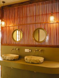 two sinks on a counter in a bathroom with two mirrors at Mateves Boutique Lodge in Arusha