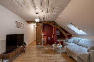 ein Wohnzimmer mit Sofa und Fernseher in der Unterkunft Le Grand Cru - Centre Ville in Saumur