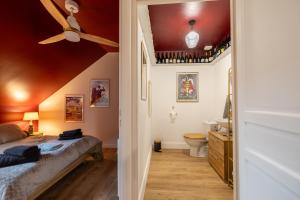 Schlafzimmer mit einem Bett, einem WC und einer Decke in der Unterkunft Le Grand Cru - Centre Ville in Saumur