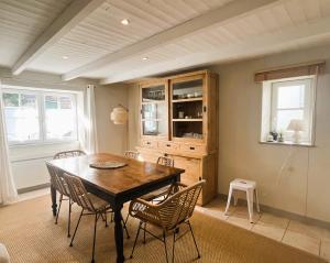 ein Esszimmer mit einem Holztisch und Stühlen in der Unterkunft ORIANE maison de charme proche Plage in Sainte-Marie-de-Ré