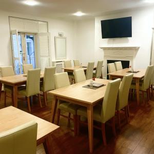 a dining room with tables and chairs and a fireplace at Hotel 63 in London