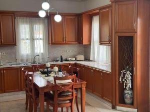a kitchen with wooden cabinets and a table with chairs at Castle Home in Meyisti