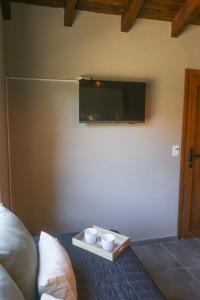 a tray with two cups and a tv on a wall at La Francisca in San Carlos de Bariloche