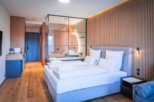 泽勒兹纳·鲁达Magnetit Hotel Šumava的一间带一张白色大床的卧室和一间浴室