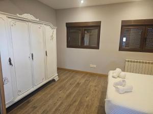 a bedroom with white cabinets and a bed and wooden floors at Casa carmen in Colunga