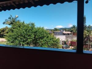 a window with a view of a palm tree at Sol do Pernambuco in Guarujá