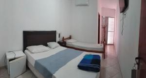 a bedroom with two beds in a room at Sol do Pernambuco in Guarujá