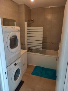 Un baño con lavadora y bañera. en F2 65m2 parking privé avec une belle vue, en Metz 21 fotos más