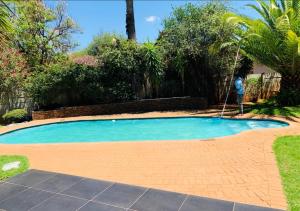 a person is mowing a swimming pool in a yard at Reitz Guest House in Mahikeng