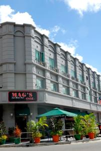 ein großes Hotelgebäude mit Pflanzen davor in der Unterkunft The Mark's Lodge in Sandakan
