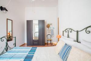 une chambre avec un lit, un miroir et une chaise dans l'établissement Sun House 4 Villasimius City Center AirConditioned, à Villasimius