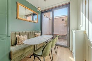 a dining room with a table and chairs and a couch at Barroco Ypres - Charmante barokwoning in hartje Ieper, 3 slaapkamers, terras & topligging in Ieper