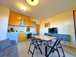 a kitchen with a table and chairs in a room at Sunny Ap in Golf Complex Lighthouse in Balchik