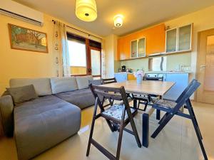 a living room with a couch and a table and chairs at Sunny Ap in Golf Complex Lighthouse in Balchik