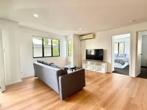 ブリスベンにあるKangaroo Point Stay - Being Everywhere at Once! Spacious 3 bedroom apartment, central location! Free carparkのソファとテレビのあるリビングルーム