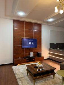 een woonkamer met een tv en een salontafel bij M2 Homes in Gwarinpa +31 foto's