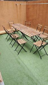 eine Gruppe Stühle und ein großer Holztisch in der Unterkunft SA 15min downtown Barcelona, 5min Metro, Beach nearby in Sant Adria de Besos