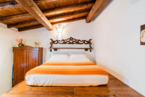 a bed in a bedroom with wooden ceilings and wooden floors at Letto & Merenda in Nardò