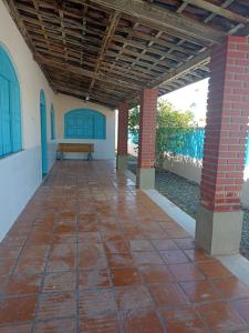a porch of a house with a bench under a roof at Casa Grande de 03 quartos em Jauá in Camaçari