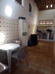 a kitchen with a white table and a white refrigerator at Casa Grande de 03 quartos em Jauá in Camaçari