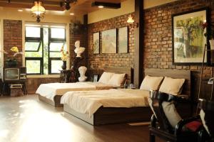 a bedroom with two beds and a brick wall at Yesterday Homestay Hue in Thôn An Hòa