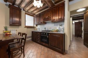 cocina con armarios de madera, mesa y comedor en La Pieve di San Martino, en Colle Val D'Elsa