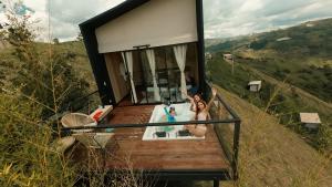 una casa con dos personas sentadas en una bañera en Cabañas para parejas cerca a Medellín - LUUM By Roots Rentals, en Marinilla