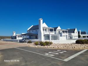 a white house with a stop sign in a parking lot at Jacobsdaller #1 in Jacobs Bay