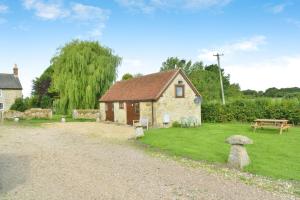 a small house with a grass yard with a bench at Willows in Calbourne +11 photos