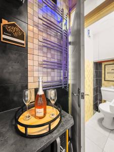 ein Badezimmer mit zwei Gläsern und einer Flasche Wein in der Unterkunft Private Spa Apartment In Maerdy Hot Tub & Sauna in Maerdy