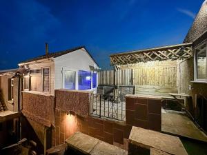 ein Haus mit einem Balkon mit einem Zaun in der Unterkunft Private Spa Apartment In Maerdy Hot Tub & Sauna in Maerdy