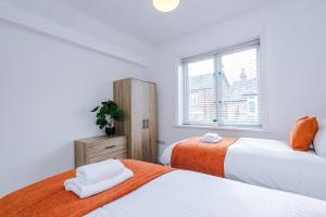 a bedroom with two beds and a window at Spacious 3-Bedroom Retreat with Modern Amenities in Hawarden