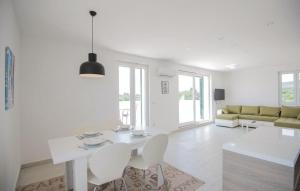 a white living room with a white table and chairs at Villa Sucuraj in Sućuraj