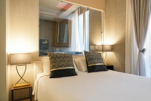 a bedroom with a large white bed with two pillows at Corso Boutique Luxury Rooms in Rome