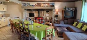 a living room with a green table and a couch at Gite de la ferme in Bertignat