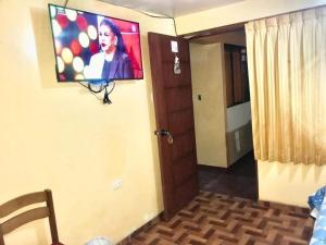 Una habitación con un televisor de pantalla plana en la pared. en Hotel & Gemeloz, en Acobamba